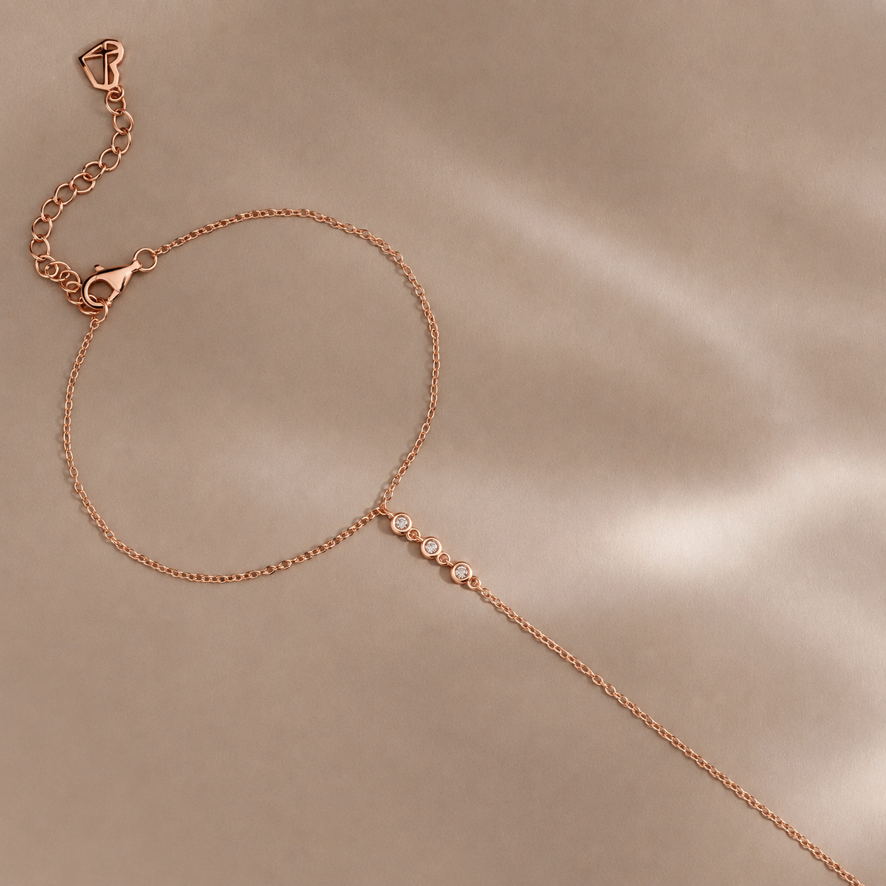 Rose gold bracelet with small diamonds on a beige background